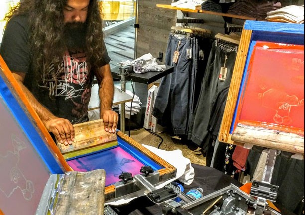 Screen printing a t-shirt live at an event activation.