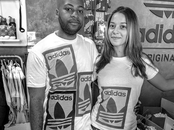 Two people wearing live screen printed t-shirts with custom designs.